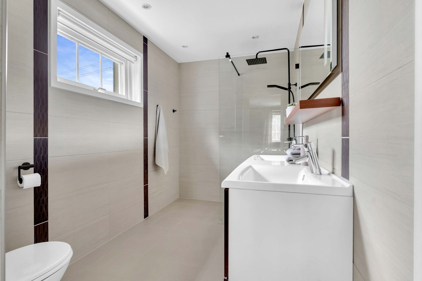 Et delikat baderom med dobbel servant, stort speil og dusj med moderne glassvegg - skapt for både hverdagskomfort og velvære. Galleribilde