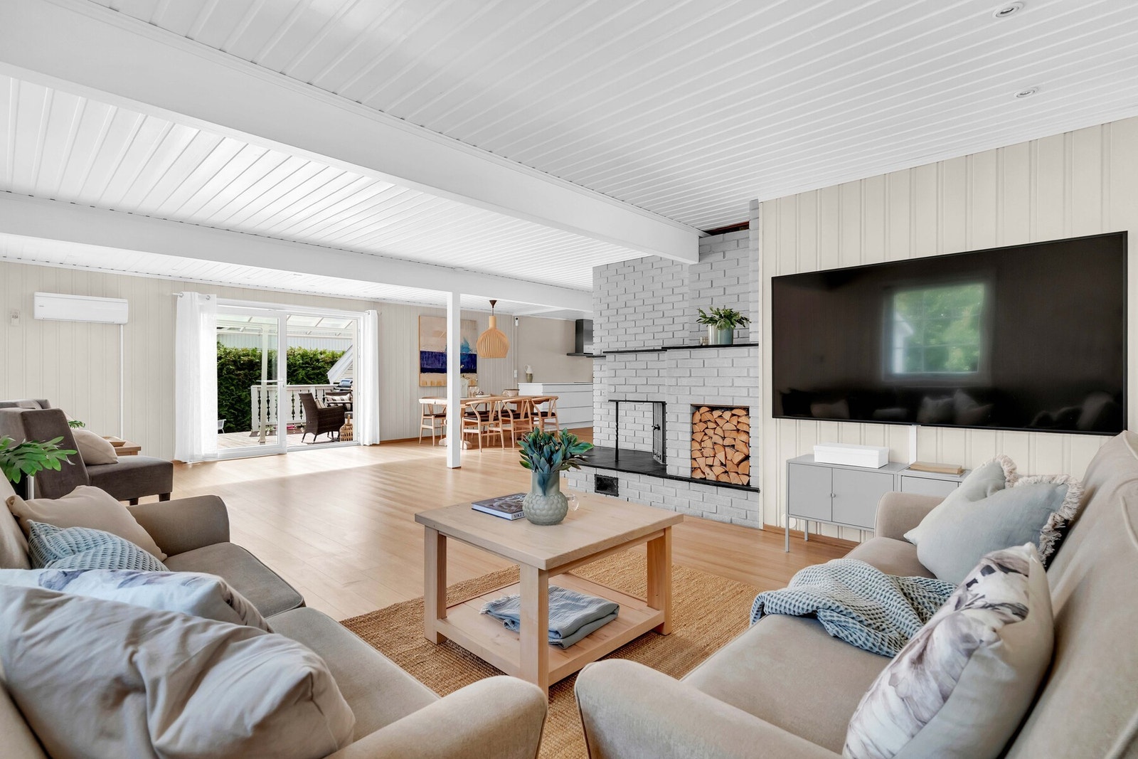 Den åpne løsningen, kombinasjonen av lys og varme og den direkte utgangen til terrassen gjør dette til hjemmets naturlige samlingspunkt. Galleribilde
