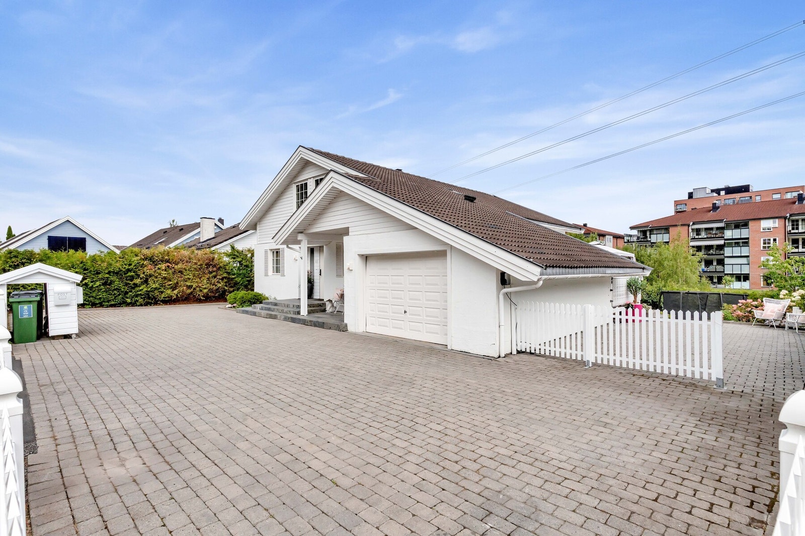 Garasjen gir både praktiske parkeringsmuligheter og et ryddig førsteinntrykk av eiendommen. Her er det montert elbil-lader. Galleribilde