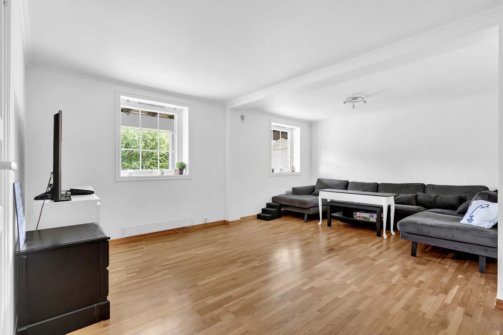 Lys og romslig stue med plass til sofakrok og TV-løsning, perfekt for et komfortabelt hverdagsliv. Galleribilde