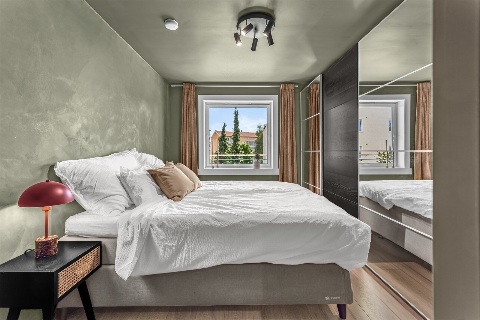 Leiligheten har et stort og luftig soverom med god plass til dobbeltseng, nattbord og medfølgende garderobeløsning. Galleribilde