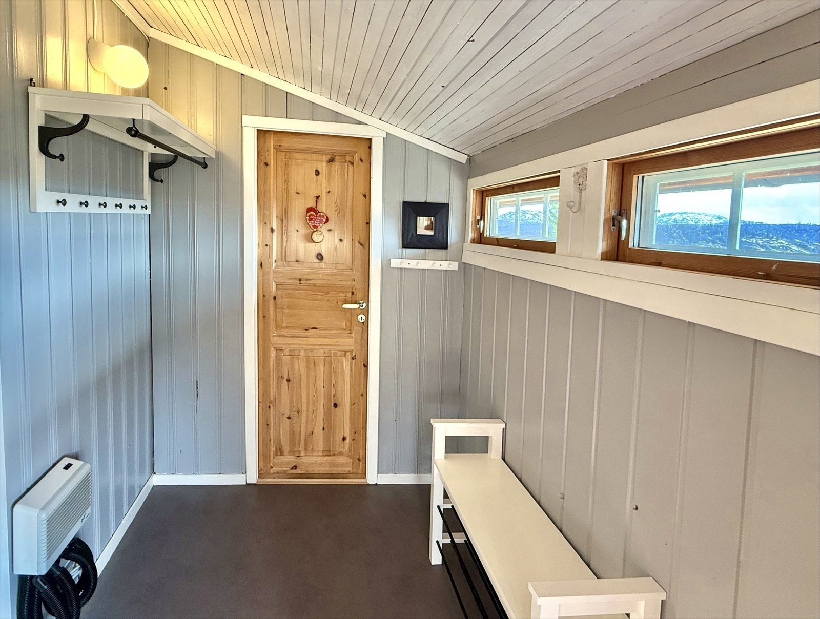 I entréen er det lagt praktisk belegg på gulv og det er fin plass til sko og yttertøy. Rett frem er det tilkomst til toalettrommet, og inn til venstre er det tilkomst til gangarealer med videre tilkomst til øvrige rom i hytta. Galleribilde