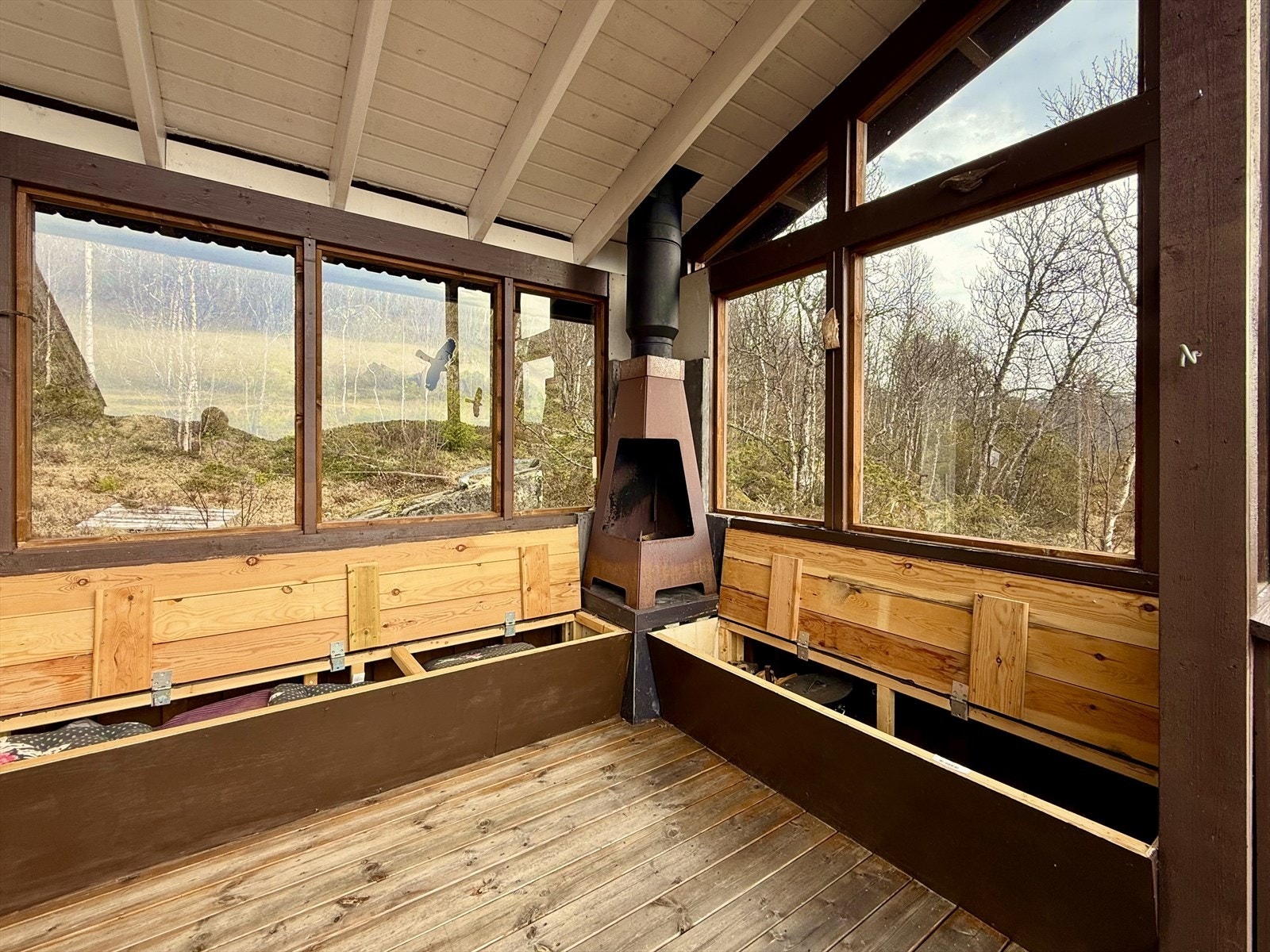 Her er det også oppført plassbygde benker med smart oppbevaringsplass under og i hjørnet er det montert utepeis med stålpipe i 2015. Galleribilde