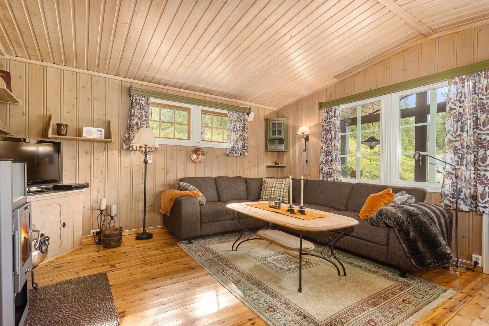 Gulvene har gulvbord, mens vegger og himlinger er kledd med trepanel som gir en lun og tradisjonell hyttestil. Galleribilde