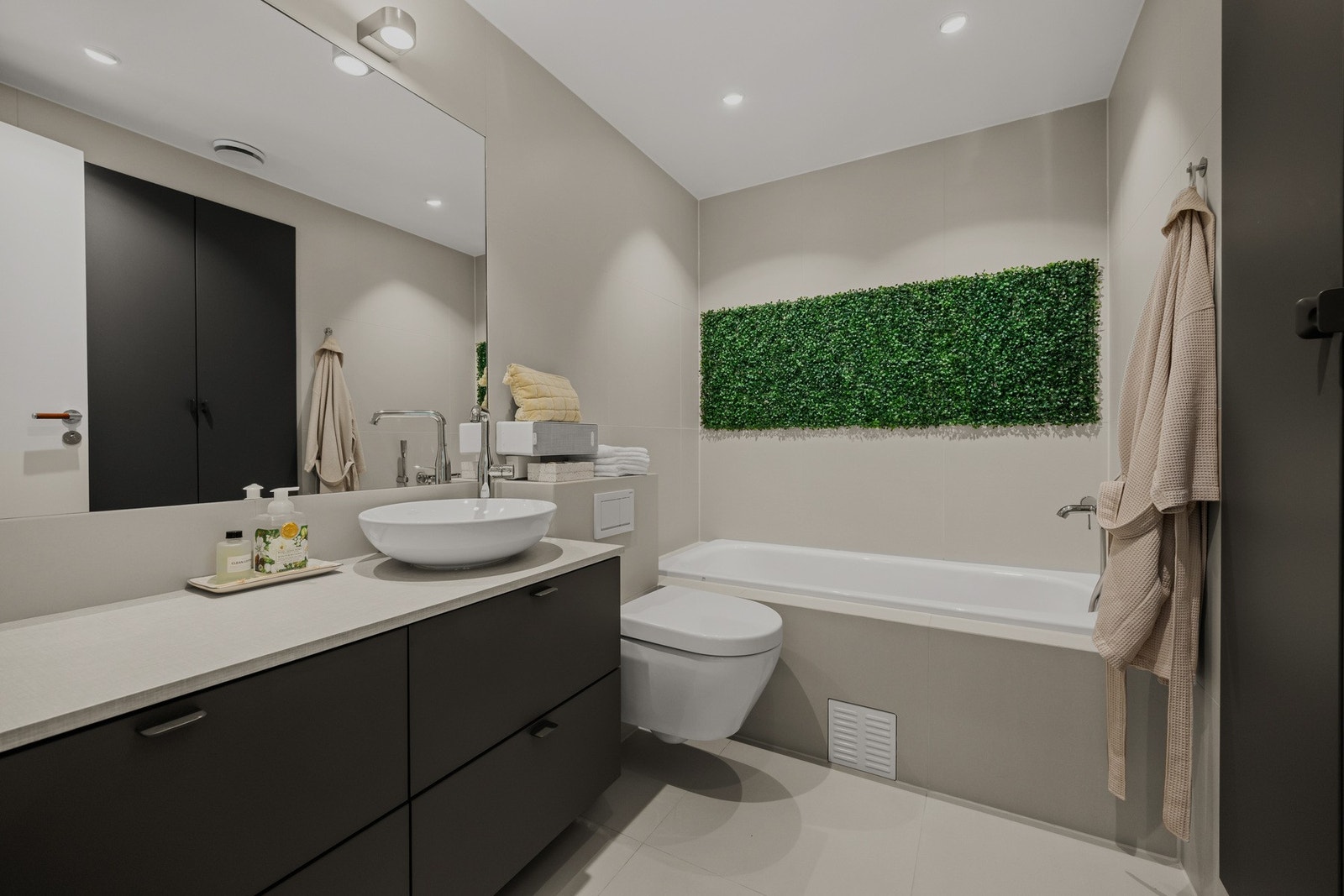 Nytt og lekkert flislagt bad med gulvvarme og integrert stikk for lading i høyskap . Galleribilde