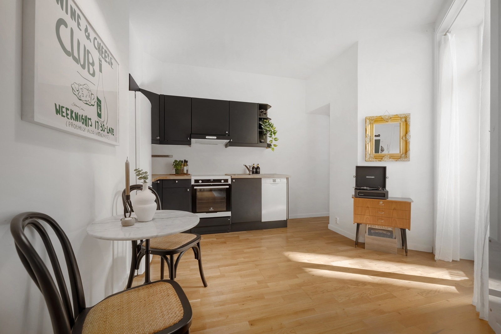 Kjøkkenet har frittstående hvitevarer som kjøleskap med frysedel, oppvaskmaskin og komfyr med platetopp Galleribilde