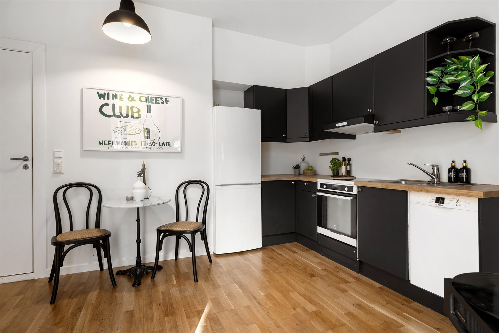 Kjøkkeninnredning med slette, mørkeblå fronter, benkeplate av laminat og nedfelt oppvaskkum i rustfritt stål med ett-greps armatur Galleribilde