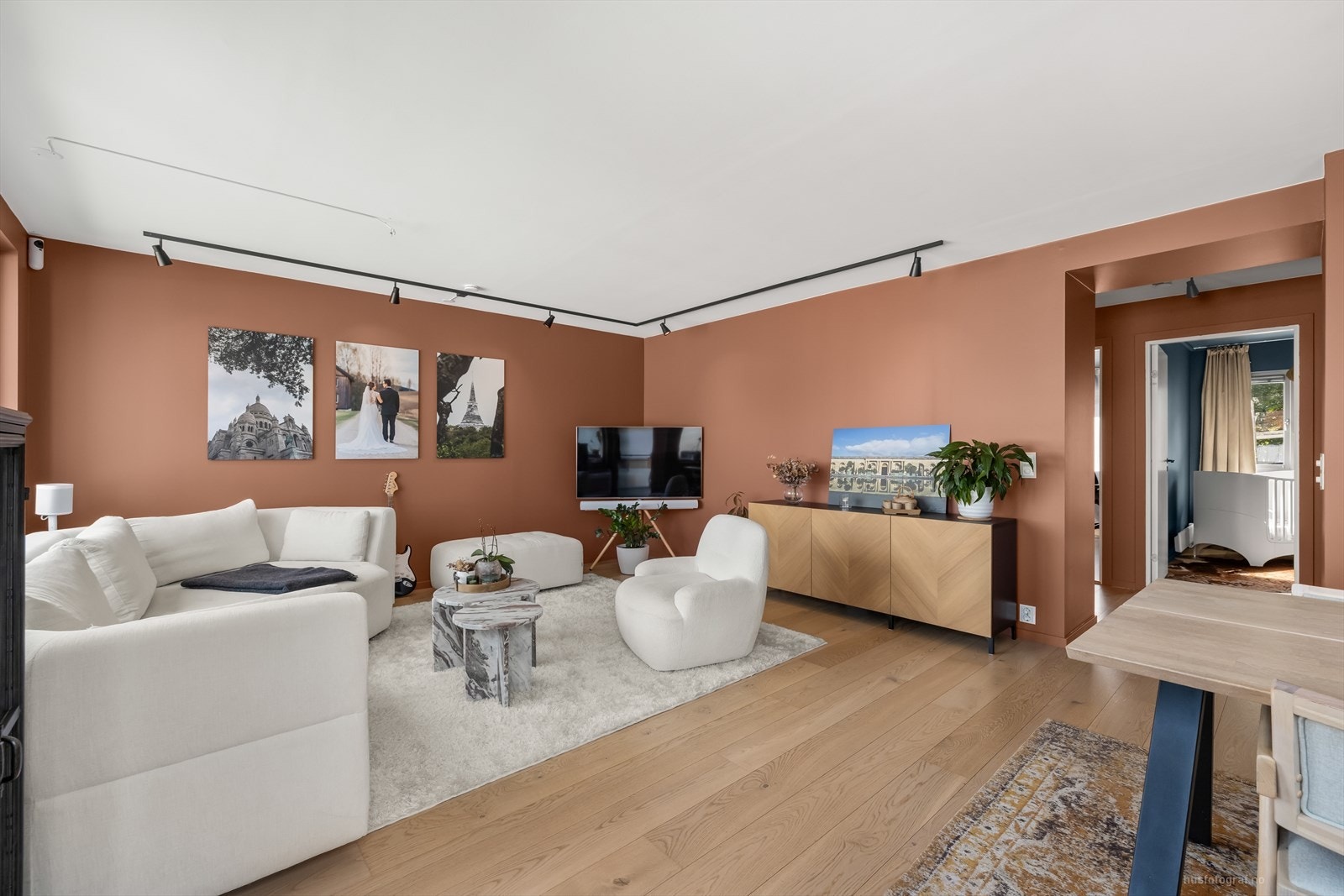 Lys og lekker stue med moderne parkettgulv og slette vegger malt i en varm og behagelig fargetone. Galleribilde