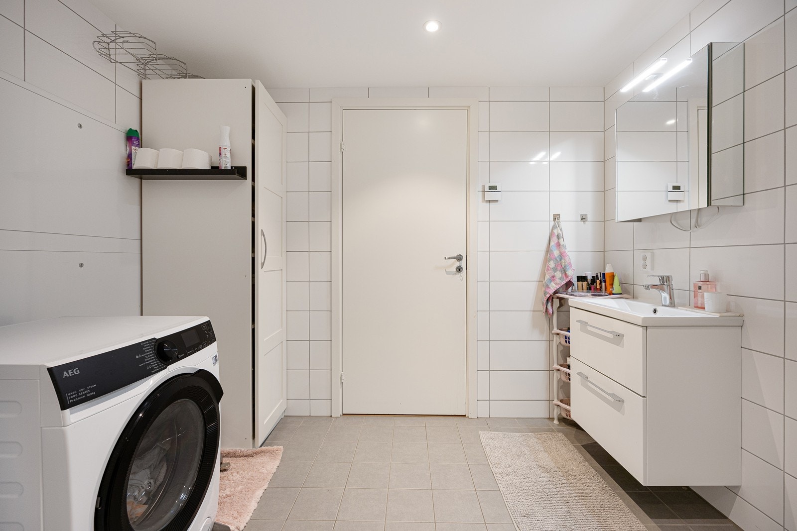 Videre har badet veggmontert toalett, dusjhjørne med innfellbare glassdører og opplegg for vaskemaskin. Galleribilde