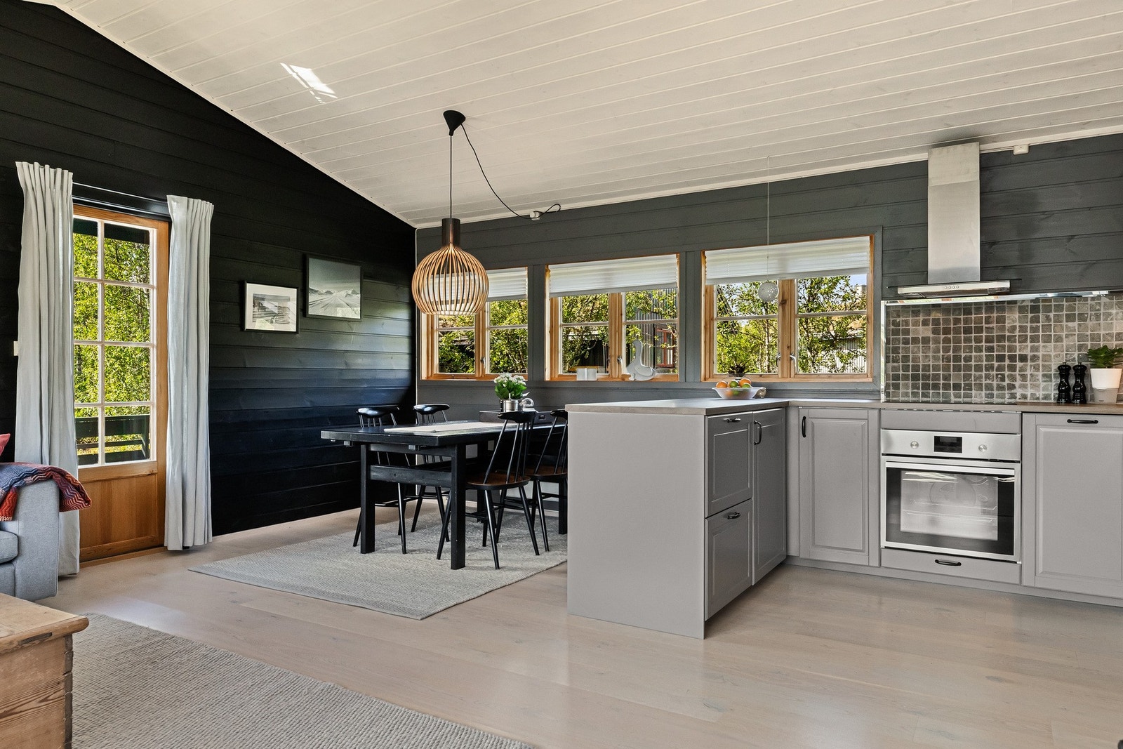 Fra vinduene flommer dagslyset inn og en kan kjenne på en god romfølelse Galleribilde