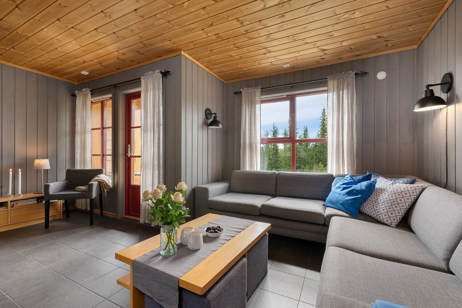 Lun og hyggelig stue med vegger malt i en delikat gråtone. Fint, naturlig lys inn i rommet. Galleribilde