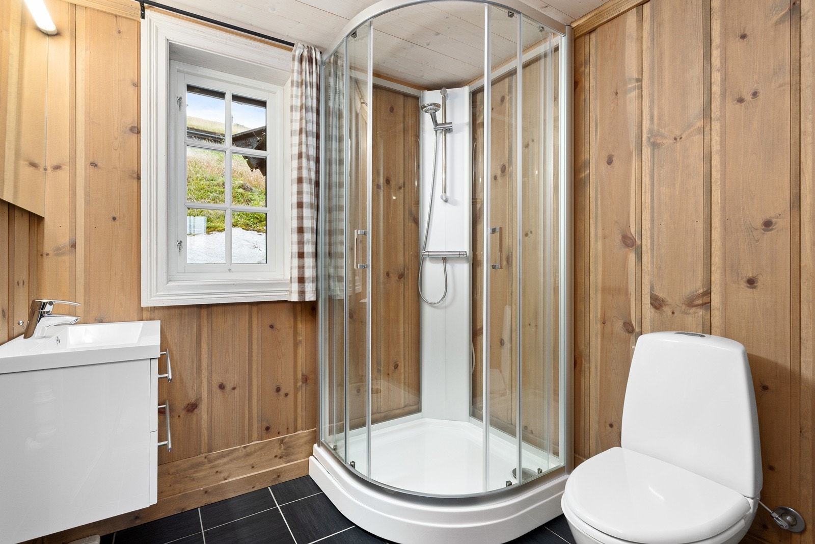 Toalettrommet er utstyrt med dusjkabinett og toalett. Galleribilde