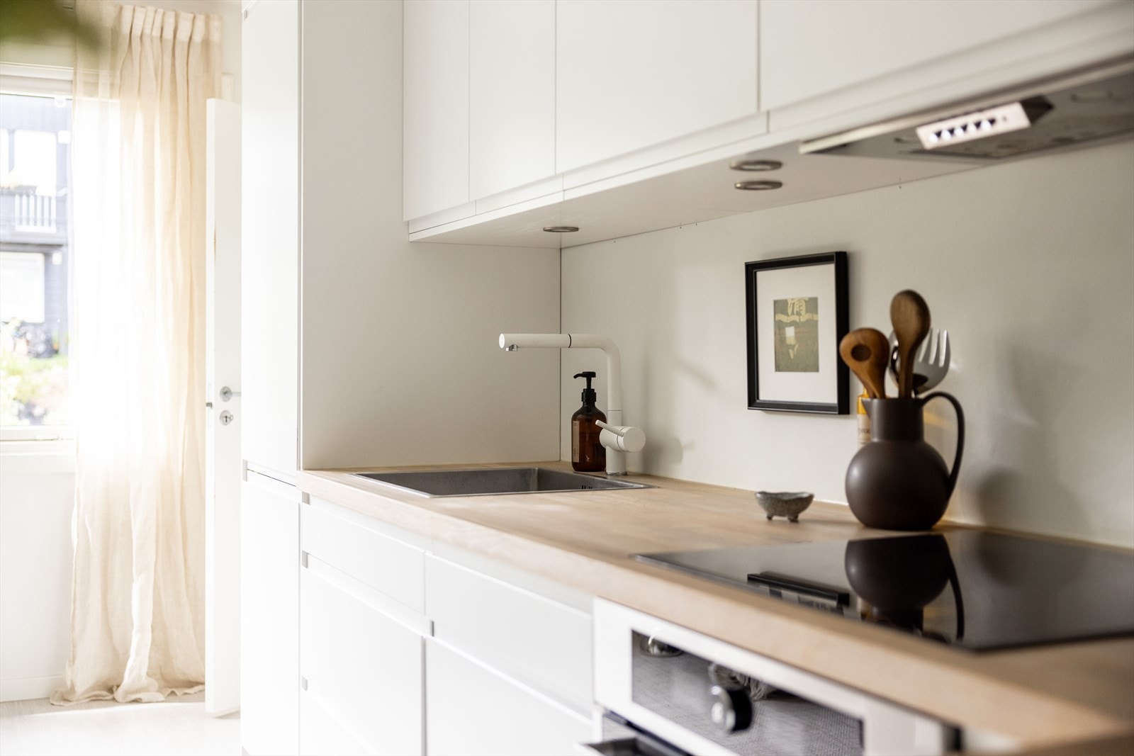 Innredningen har glatte fronter, heltre benkeplate med nedfelt vaskekum samt belysning over arbeidsflaten. Galleribilde