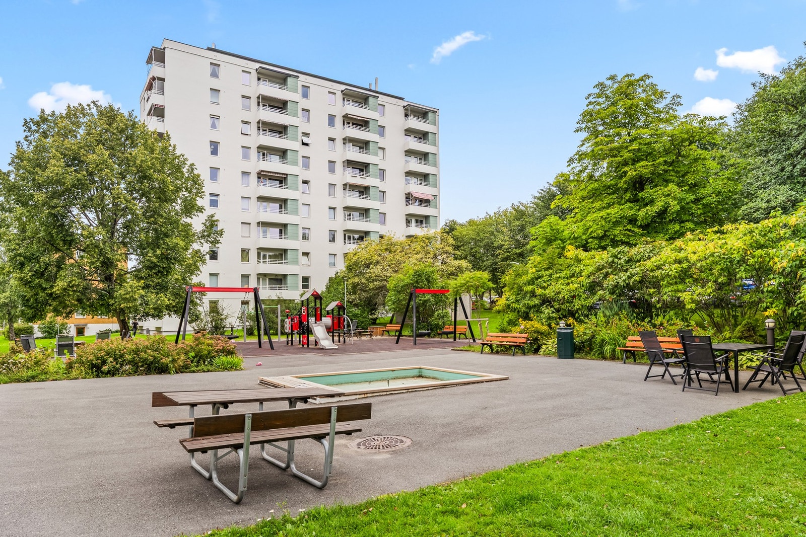 Det er en moderne og innholdsrik lekeplass utenfor blokken. Galleribilde