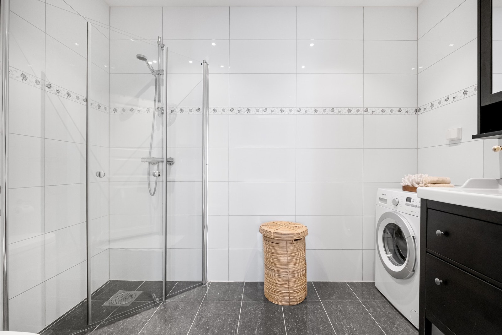 Det lekre badet har lyse veggfliser og mørkere gulvfliser som gir en fin kontrast. Galleribilde