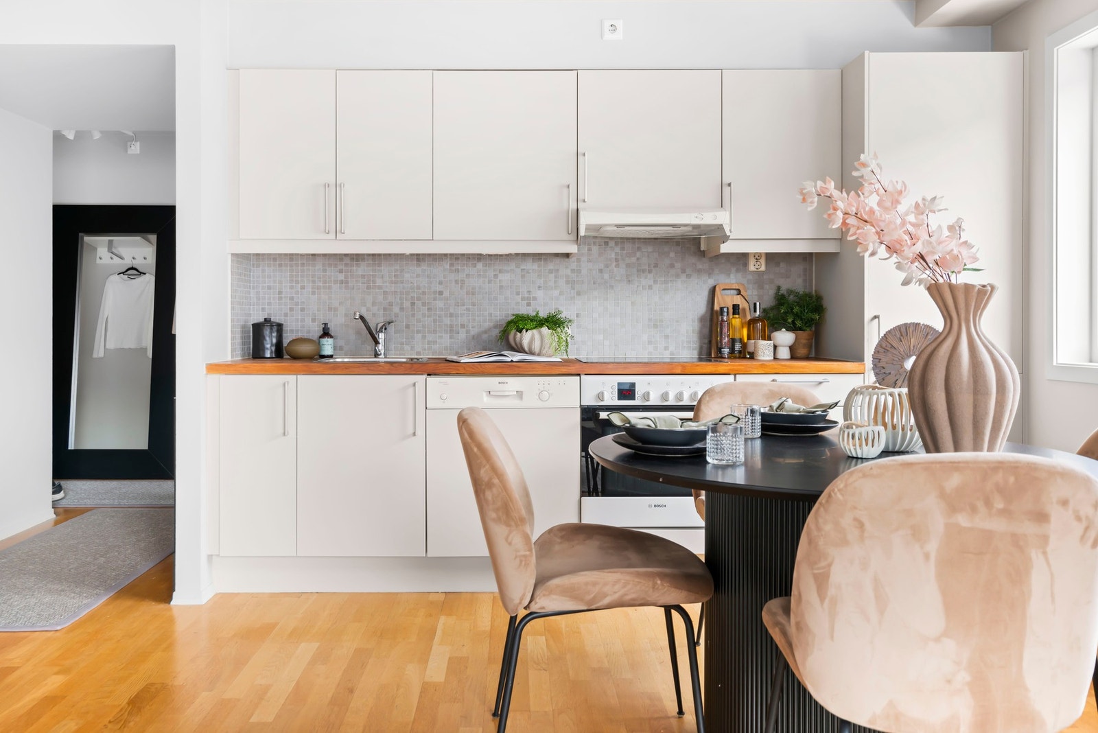 Kjøkkenet har hvite fronter, og en benkeplate i tre. Det er induksjon og oppvaskmaskin. Galleribilde