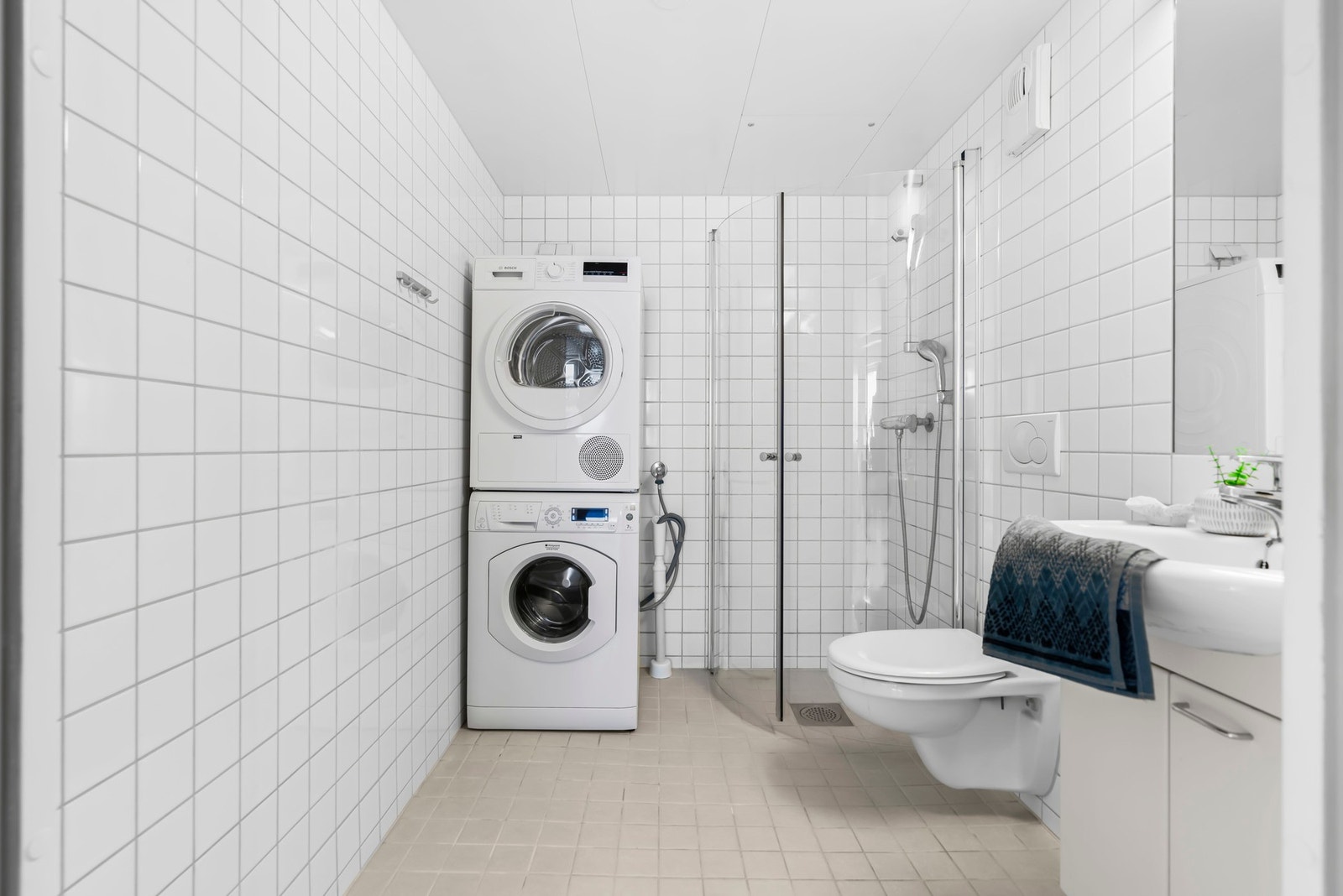 Baderommet har flislagte vegger og gulv. Det er vegghengt klosett og mulighet for vask-og tørkemaskin. Galleribilde