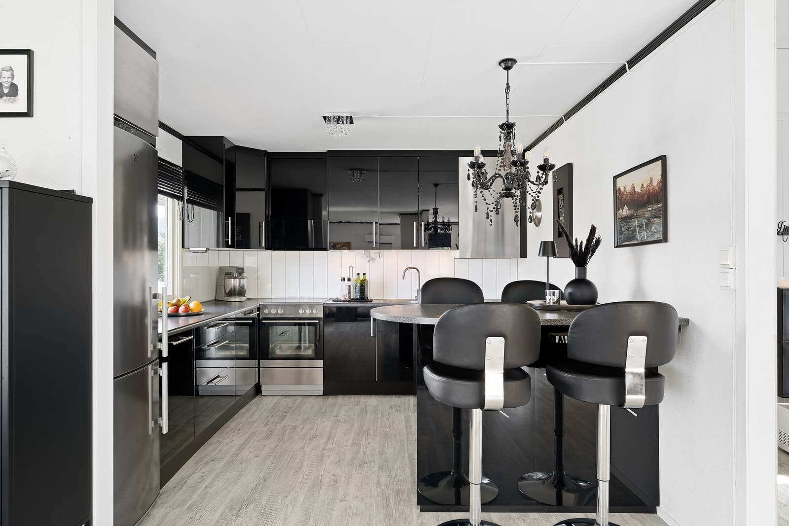 Romslig kjøkken med forhøyet kjøkkenøy som fungerer som frokostbord Galleribilde