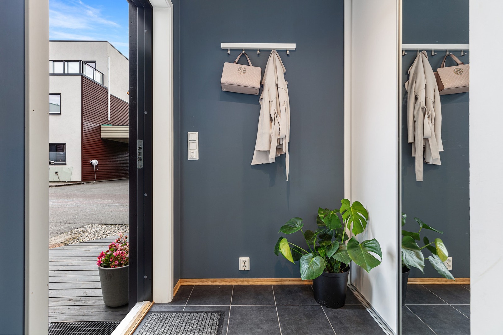 Boligen har en romslig gang med flislagt gulv og integrert skyvedørsgarderobe - Her er det masse oppbevaringsplass til sko og yttertøy Galleribilde