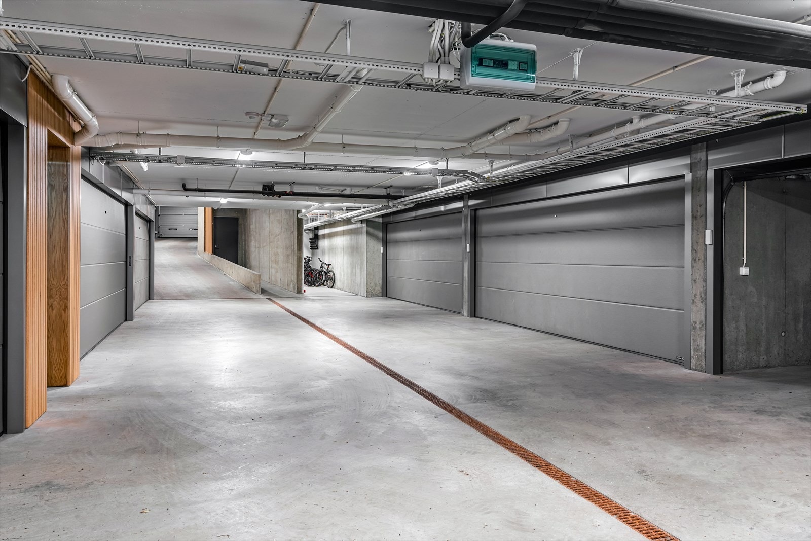 Det medfølger to garasjeplasser bak egen port, med el.bil-lader. Plassene er rett ved heisen, som går direkte opp til leiligheten. På fellesarealet er det sykkelparkering med mulighet for vask av sykler, og smørebord/-profil for ski. Galleribilde