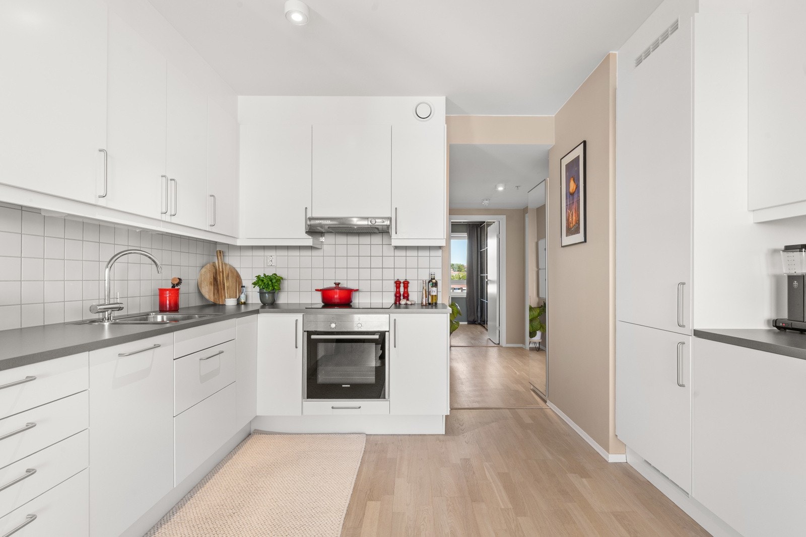 Kjøkkenet er utstyrt med integrerte hvitevarer som induksjonstopp, stekeovn, oppvaskmaskin og kjøl/frys.Rikelig med skap- og benkeplass på begge sider. Galleribilde