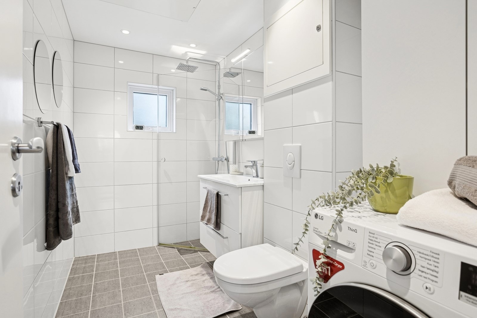 Badet er utstyrt med servant med innredning, vegghengt toalett, dusjnisje og opplegg for vaskemaskin. Galleribilde