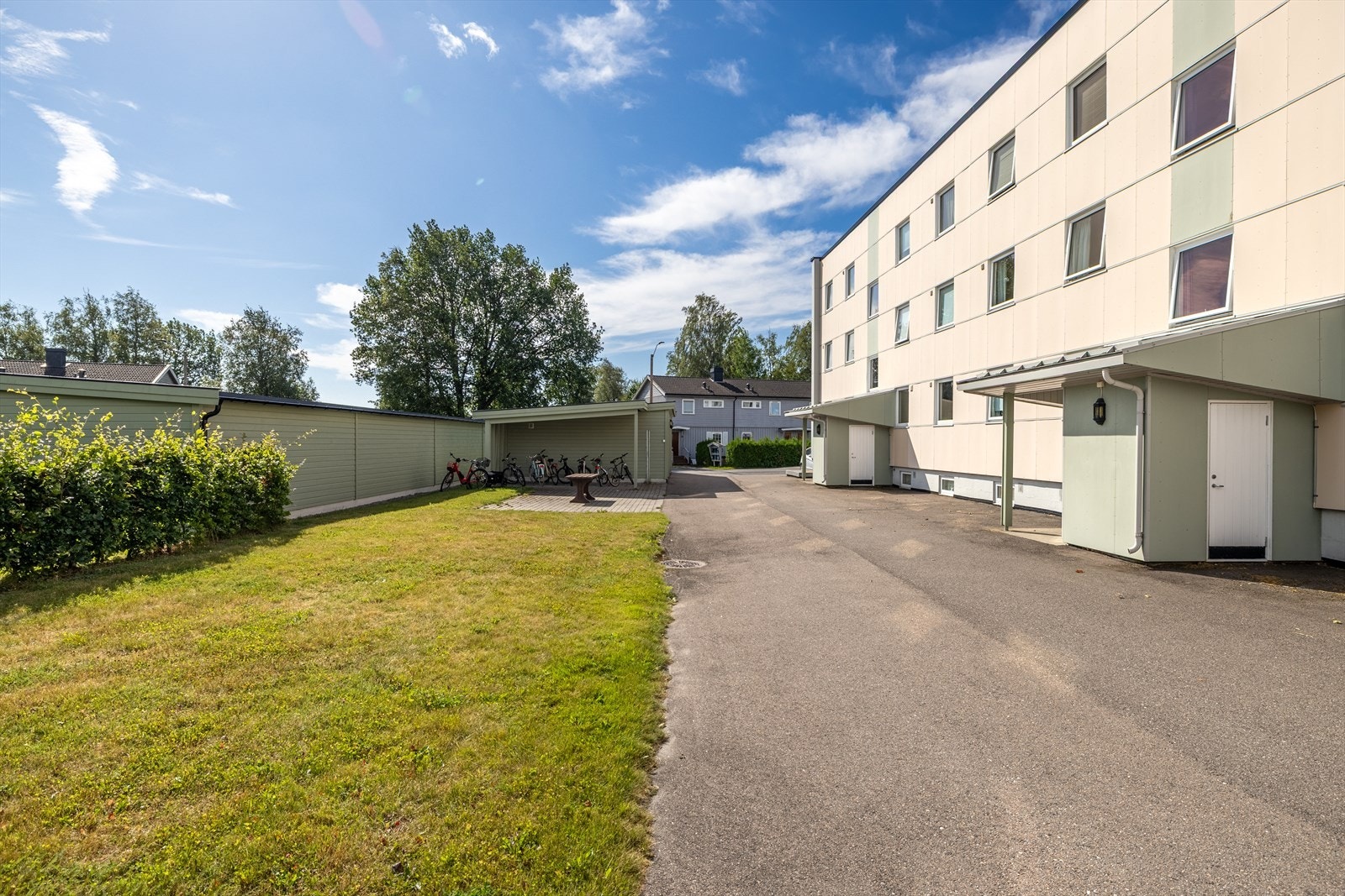 Tomten er opparbeidet med asfalt, plen og beplantning Galleribilde