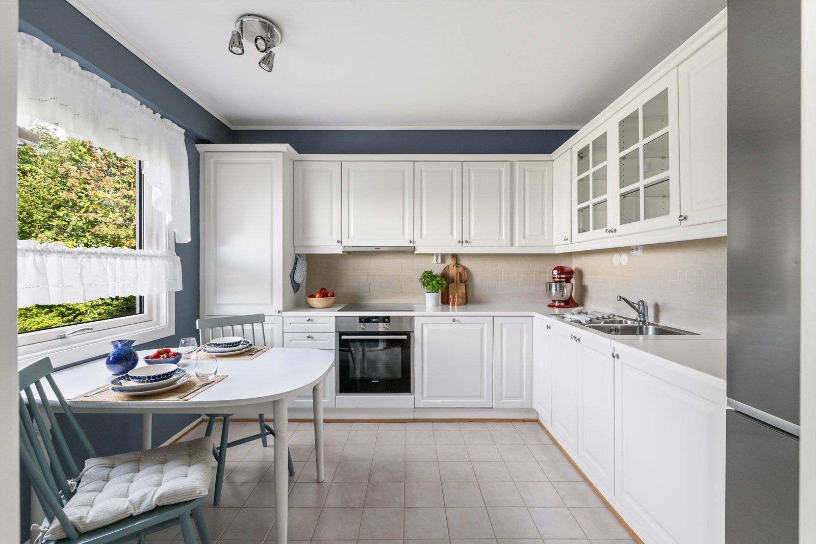 Lyst og innbydende kjøkken med profilerte fronter og benkeplate i laminat Galleribilde