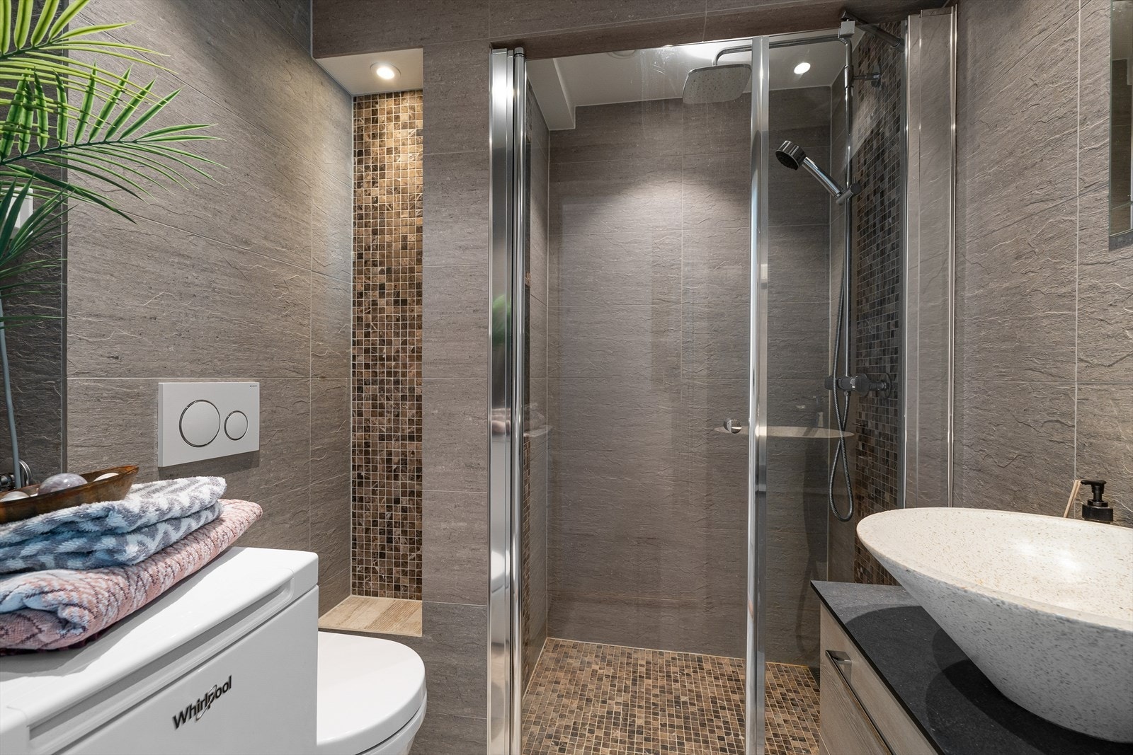 Delikat og flislagt bad med stor dusjnisje. Gulvvarme og opplegg til vaskemaskin. Galleribilde