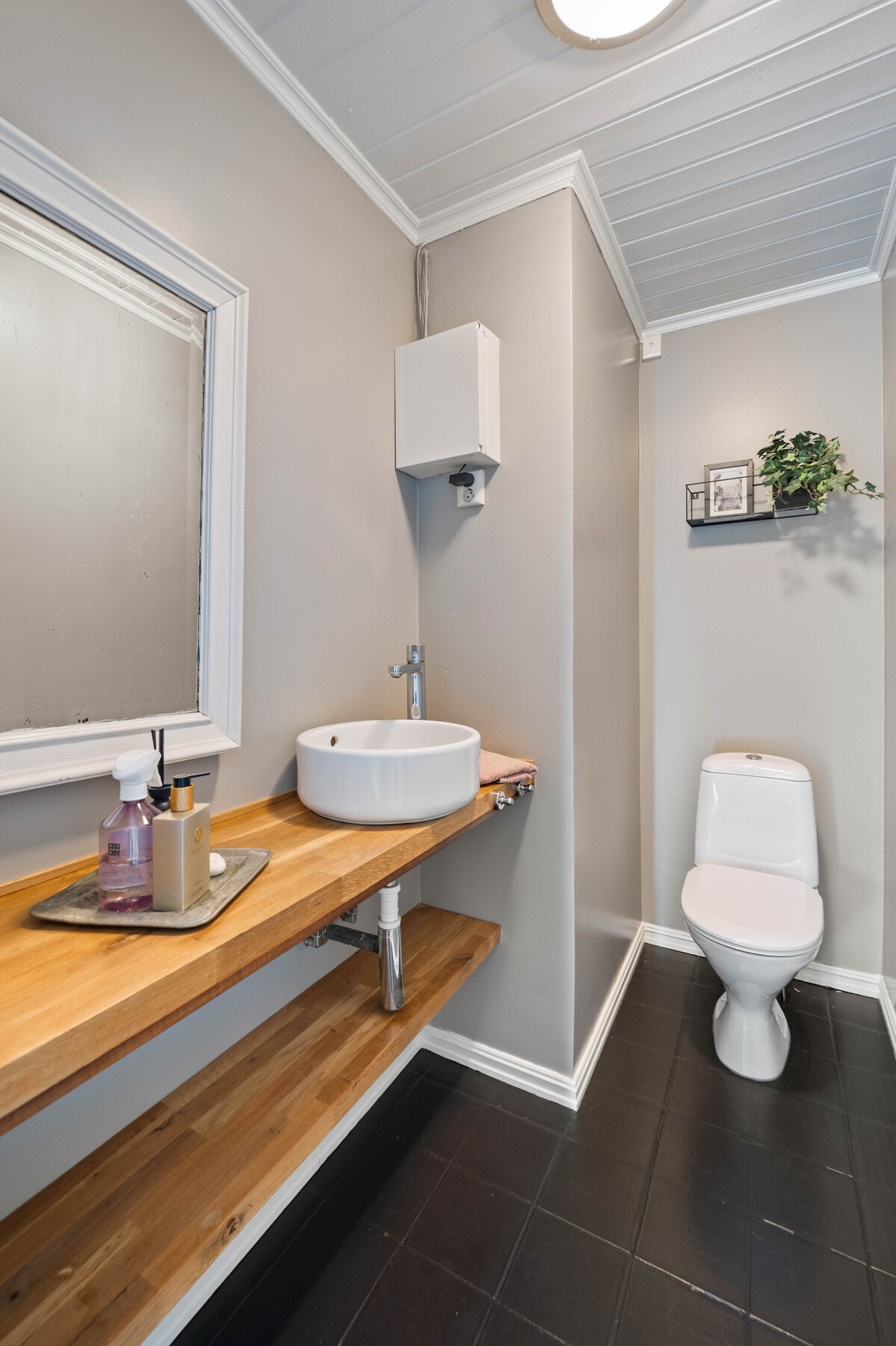 Gulvflisene fra entreen fortsetter inn på et gjestetoalett med nytt wc montert i 2025. Galleribilde