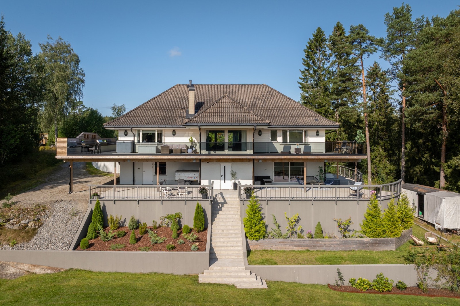 På midten har betongterrassen en trapp ned til hagen, med videre adkomst til vannet. Galleribilde