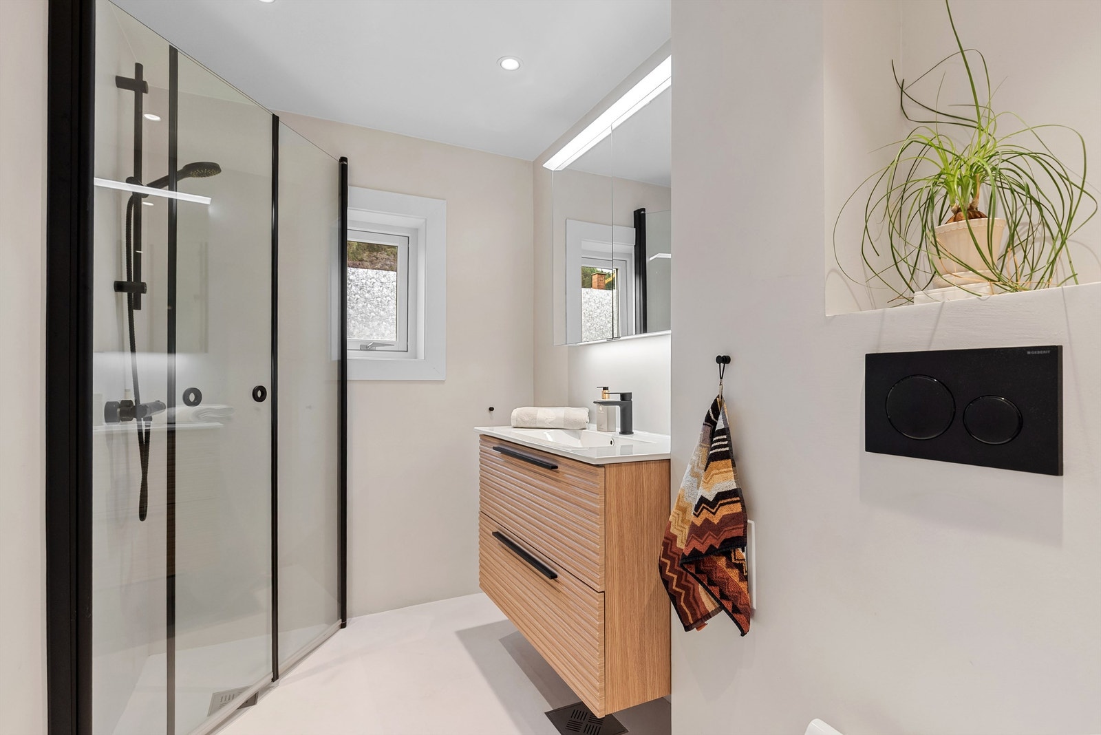 Delikat bad som ble overflateoppusset i 2021 med microsement, ny baderomsinnredning og downlights Galleribilde