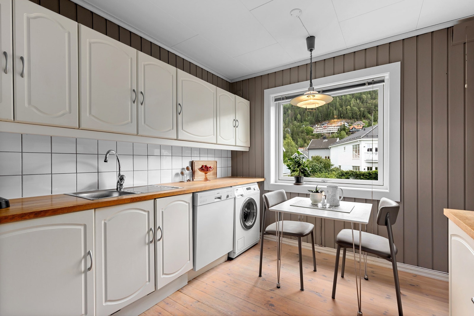 Det er plass til et frokostbord under vinduet hvor man har grønt utsyn Galleribilde