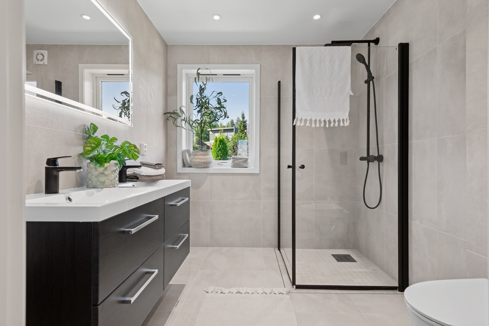 Stilrent baderom 1. etg. utstyrt med en dobbelservant med underskap, dusjvegger og vegghengt wc. Varmekabler i gulv. Galleribilde