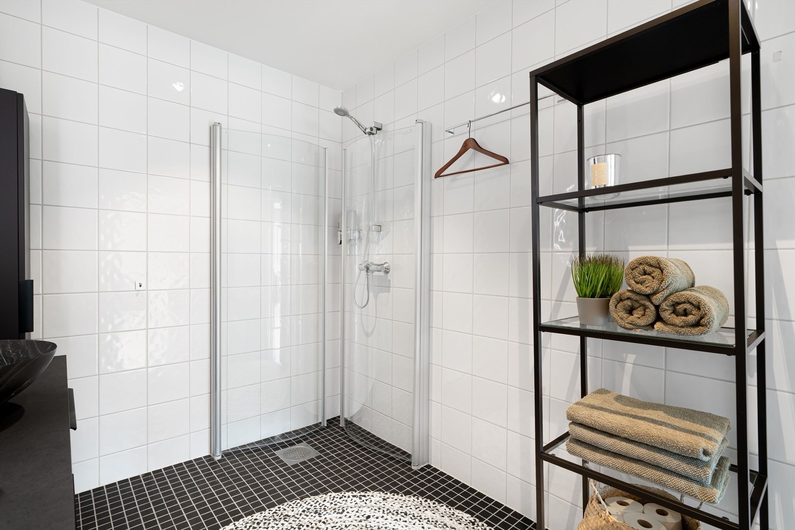 Badet er helfliset og har et moderne dusjhjørne med innfellbare glassdører - en stilfull løsning som utnytter plassen godt. Galleribilde