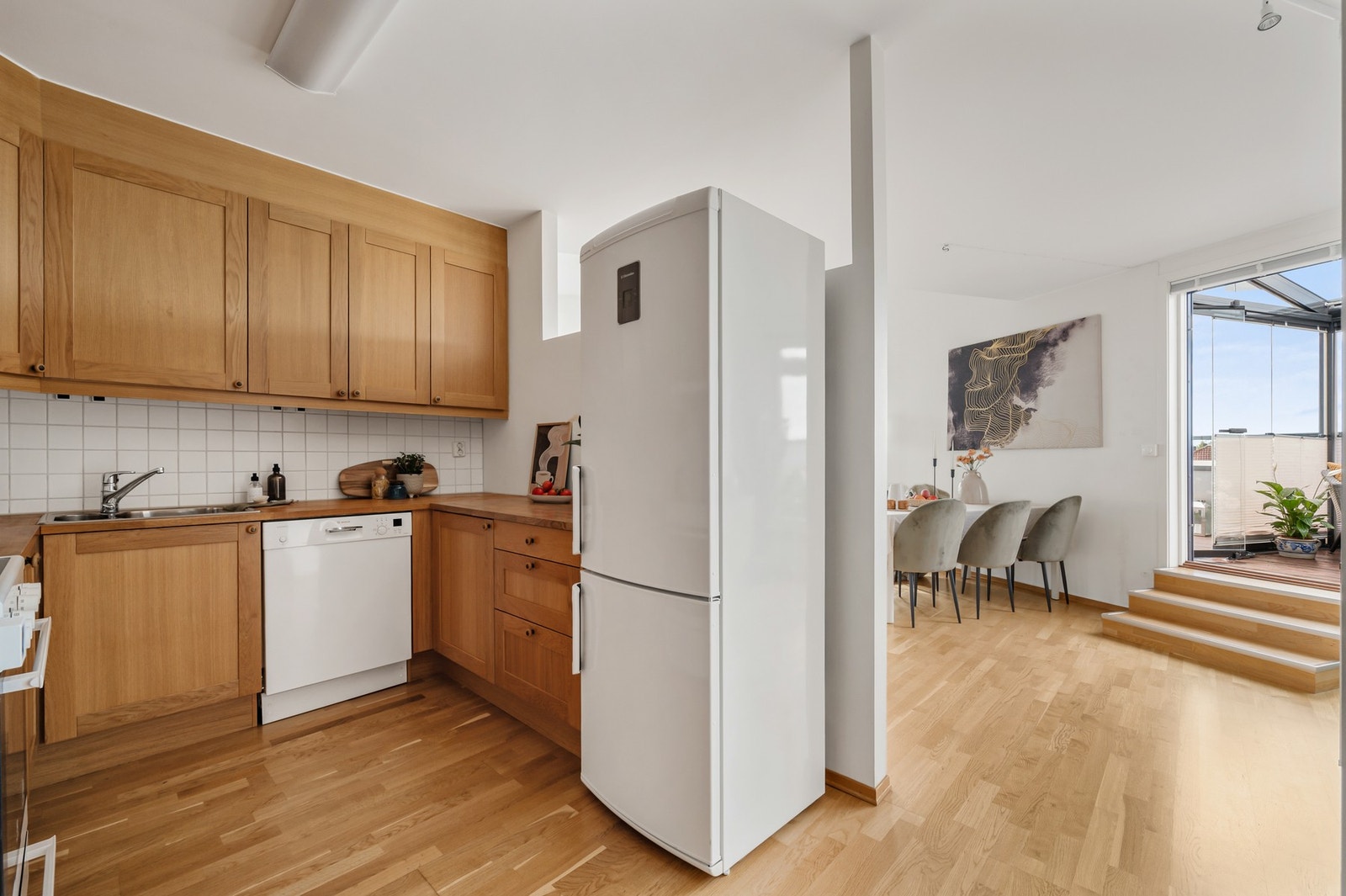 Pent og klassisk kjøkken i delvis åpen løsning mot spisestue. Galleribilde