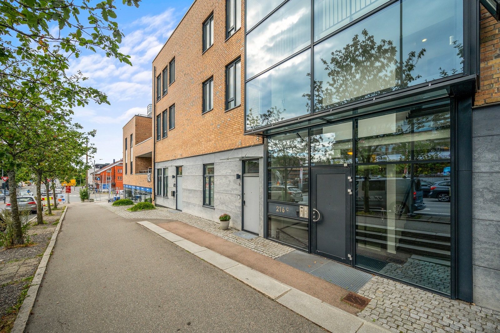 Inngangsparti på østsiden med porttelefon og glassfasade. Galleribilde