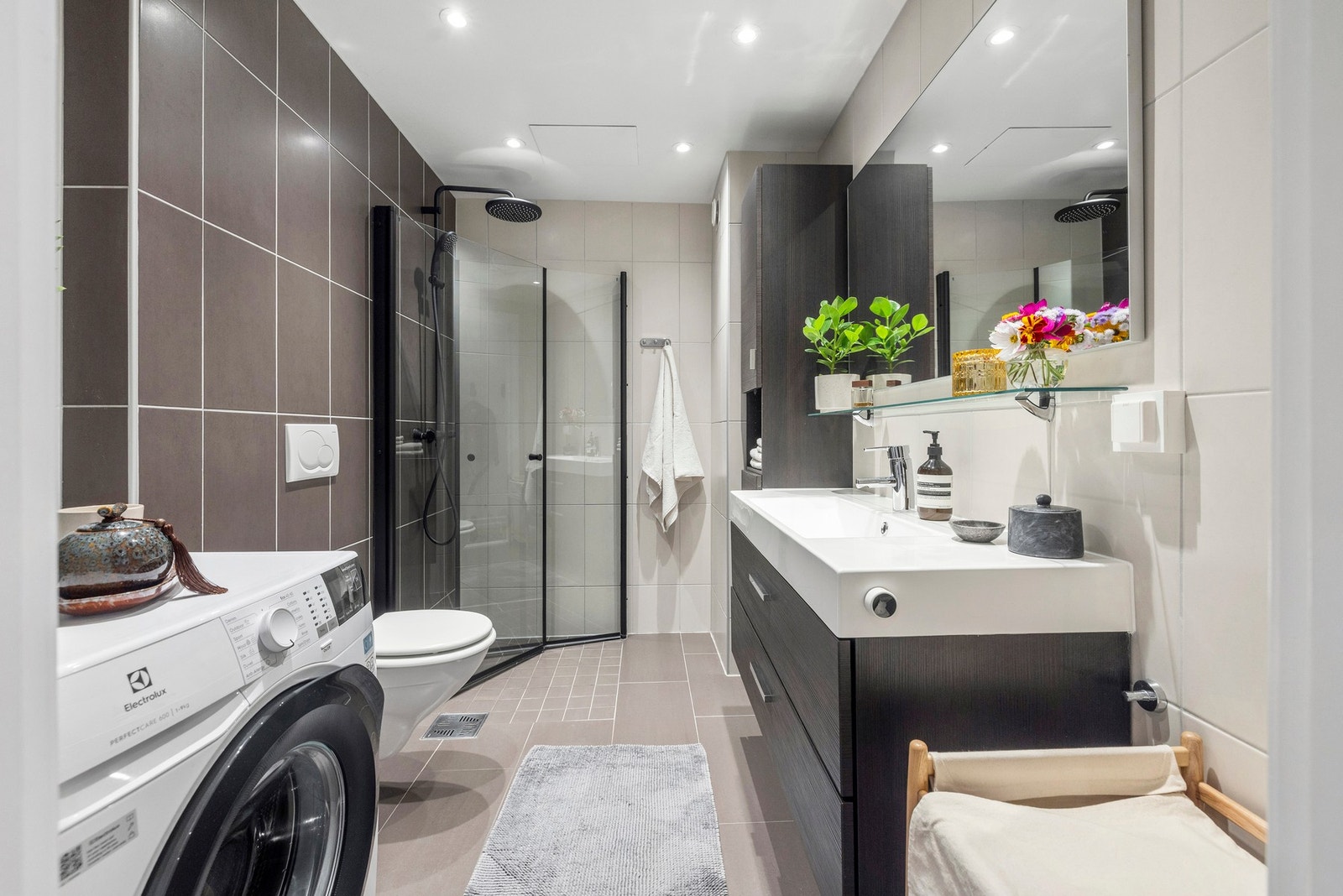 Baderommet fremstår som stilrent og delikat, med en gjennomført kombinasjon av både mørke og lyse fliser på gulv og vegger. Galleribilde