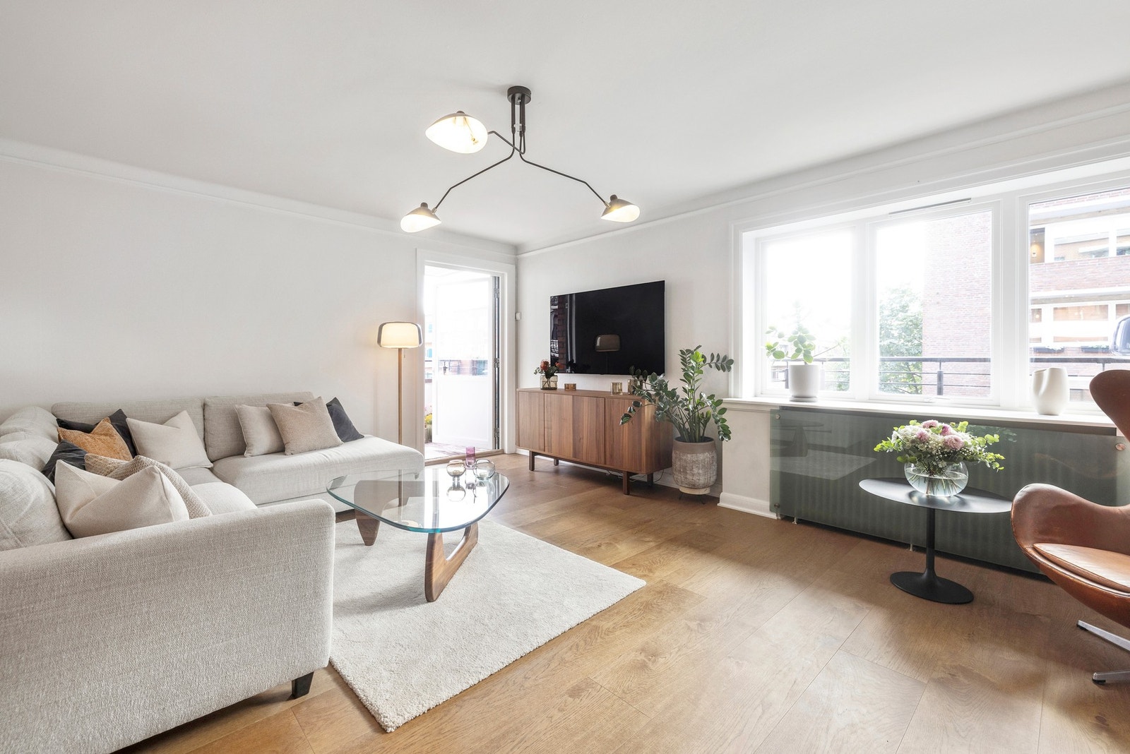 Hjørnestuen med vakkert lysinnslipp og raus takhøyde, åpner seg mot en skjermet og lun balkong som forlenger oppholdsrommet. Galleribilde