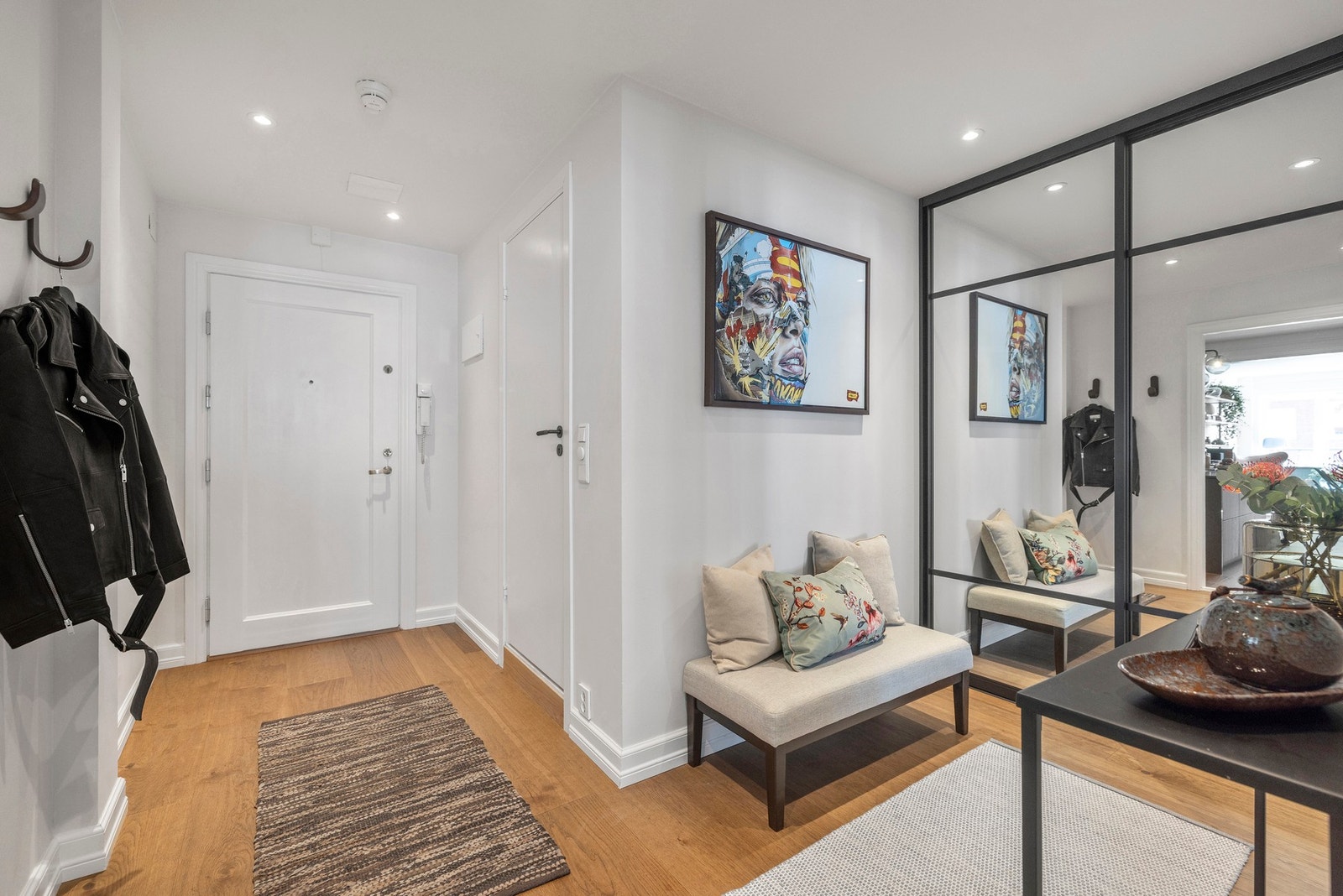 I entréen er det satt inn en stor skyvedørsgarderobe med elegante speilfronter som både gir rikelig oppbevaringsplass og bidrar til å forsterke romfølelsen. Galleribilde