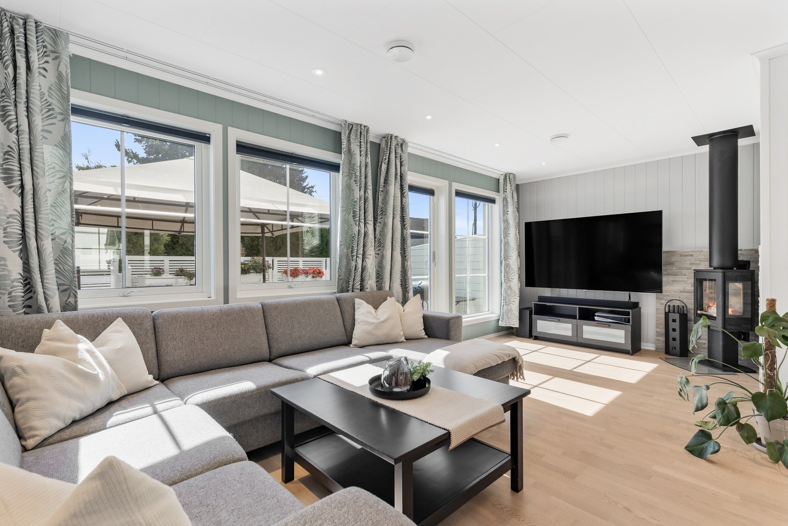 Innbydende stue med parkett på gulv, panel på vegger og takplater i himling med downlights Galleribilde