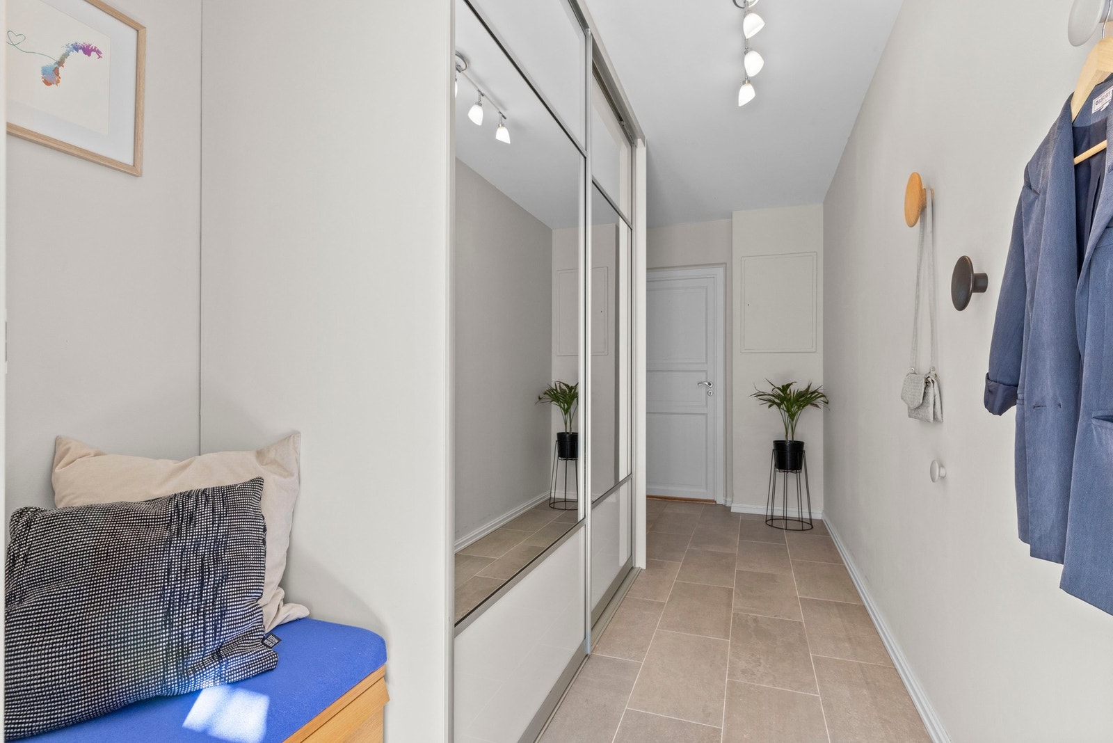 Lys og innbydende entré med god plass til oppbevaring i skyvedørsgarderobe med speilfronter. Galleribilde