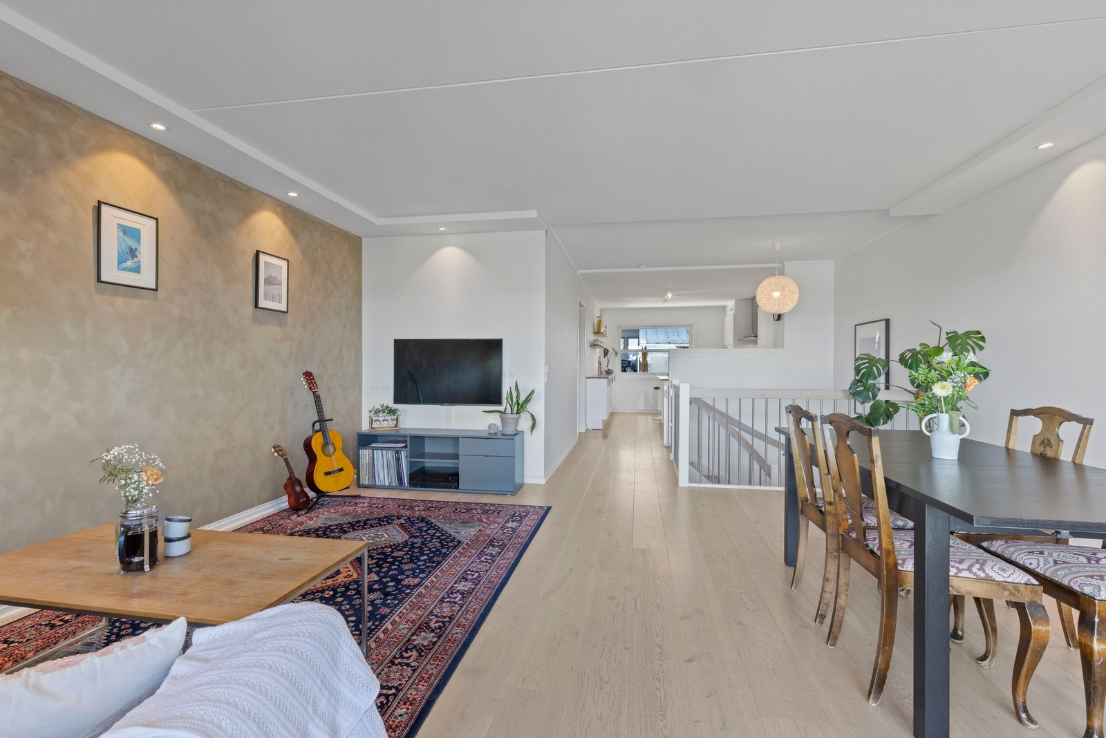 Åpent og funksjonelt oppholdsrom - kjøkken på ene enden, stue og spiseplass på den andre. Galleribilde