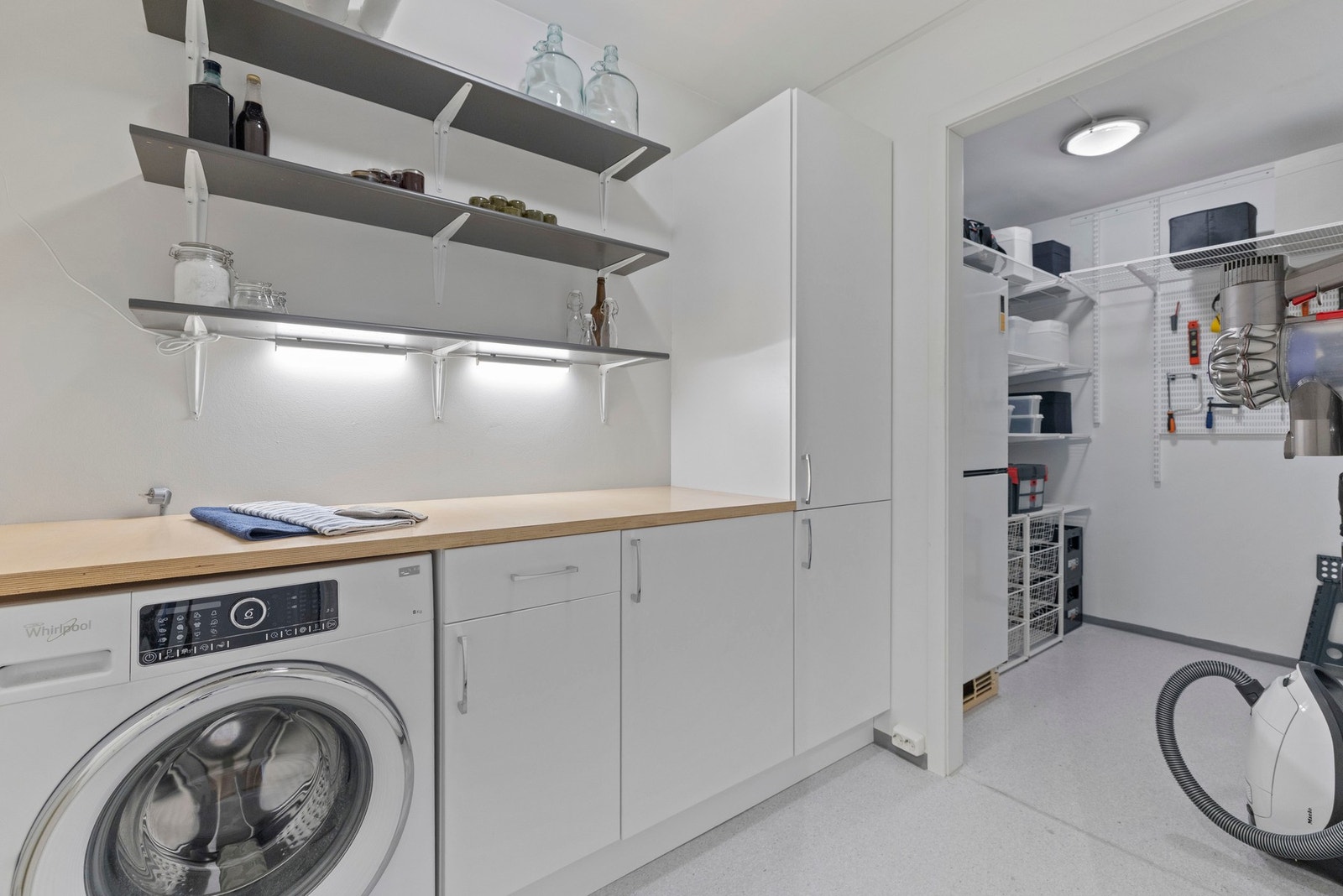 Praktisk vaskerom med god benkeplass, skap- og hylleplass. Galleribilde
