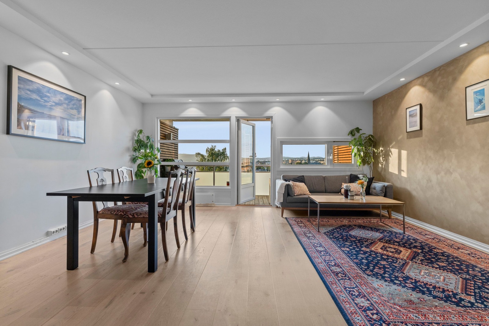 Lys og romslig stue med lekker enstavs eikeparkett på gulv og lyse flater. Galleribilde