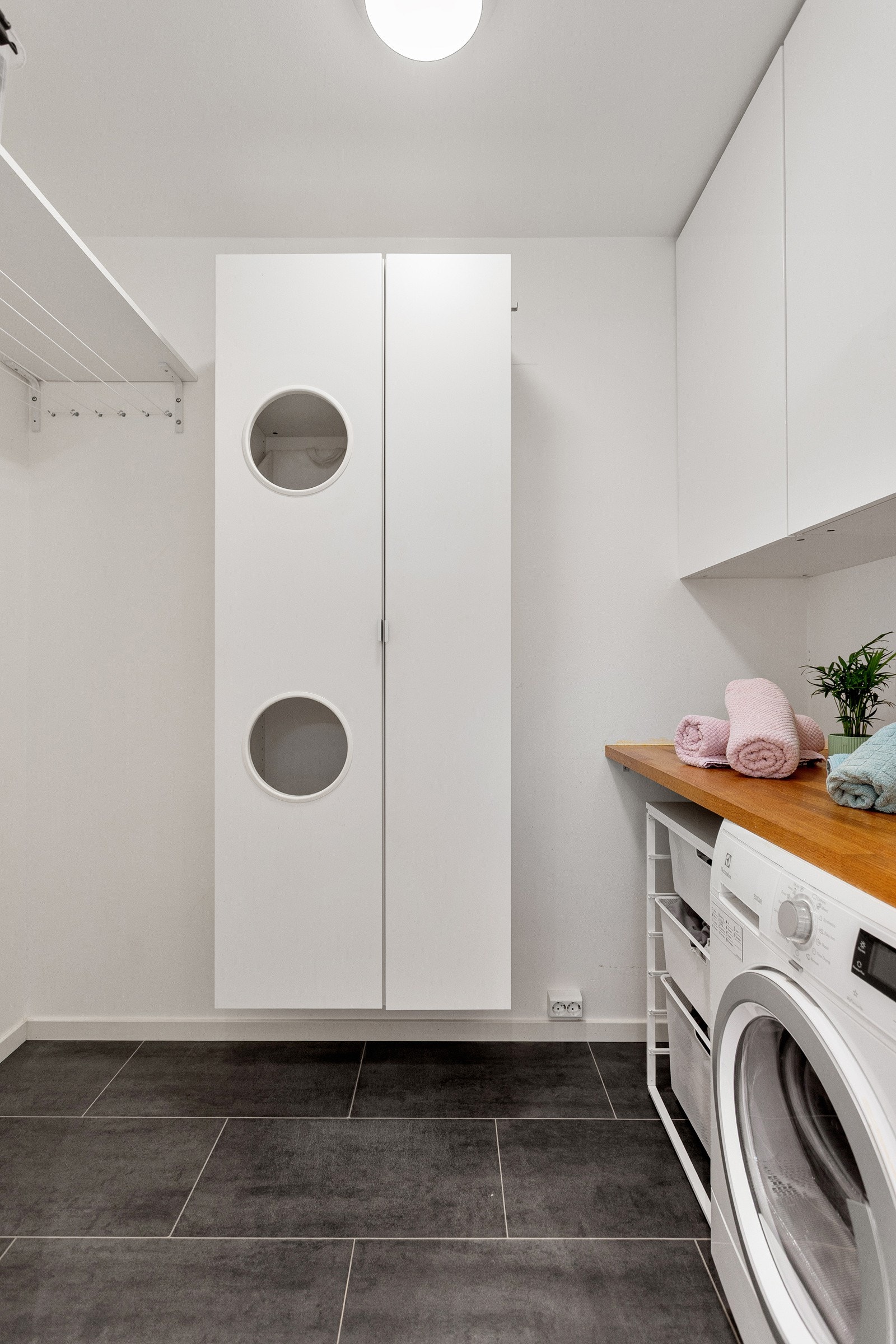 Smart tørkerom med varmefolie, skap, benkeplate, opplegg for tørketrommel og tørkesnorer i bakkant av badet. Galleribilde