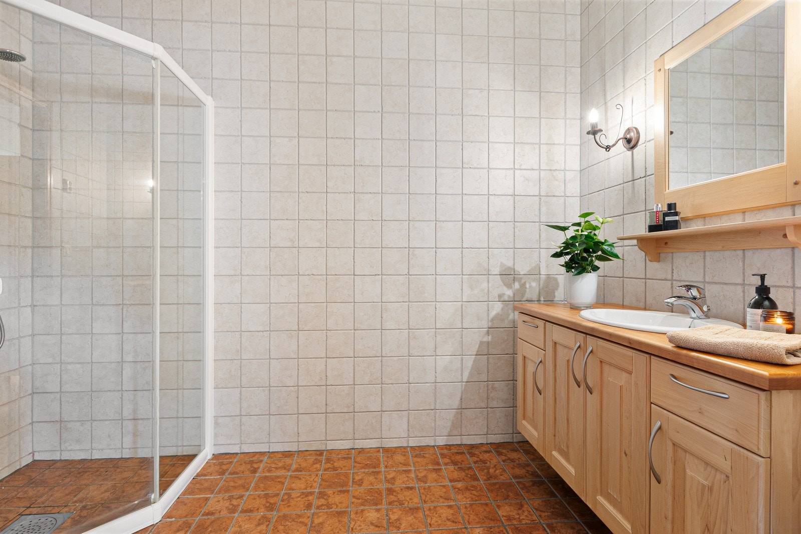 Flislagt baderom med varme i gulv (som resterende gulv i 1.etasje). Rommet er innredet med dusjhjørne med tett sokkel, servantinnredning med speil og toalett. Galleribilde