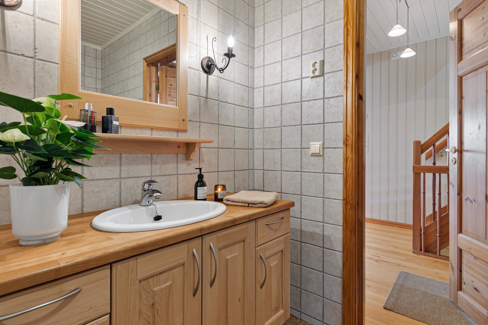 Ved siden av rommet er det første badet plassert. Baderomsinnredningen er fra Syversen snekkeri og har en innredning i svartor og benkeplate i kirsebær heltre. Galleribilde