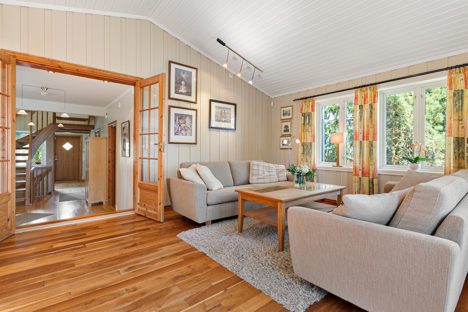 Oppe i stuen er det store vinduer som slipper inn rikelig med naturlig dagslys og rommet gir en god atmosfære. Galleribilde