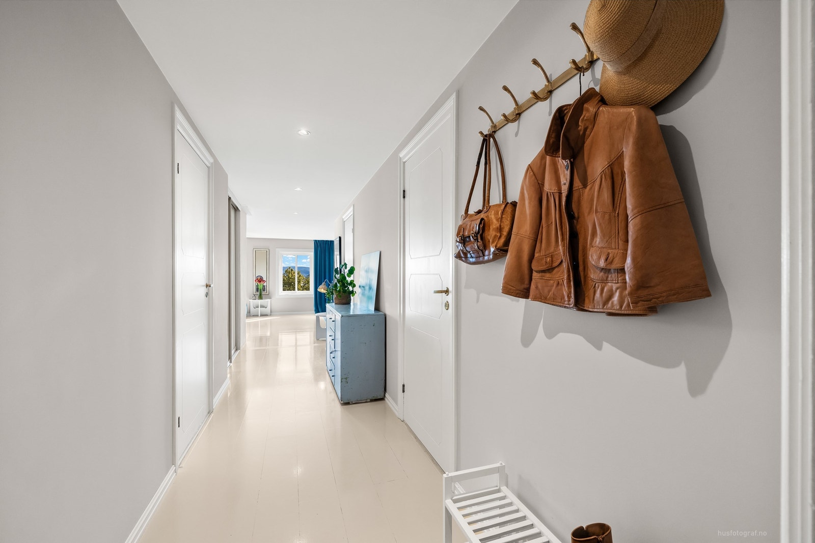 Entré/gang med innebygget skyvedørsgarderobe som har speilfronter Galleribilde